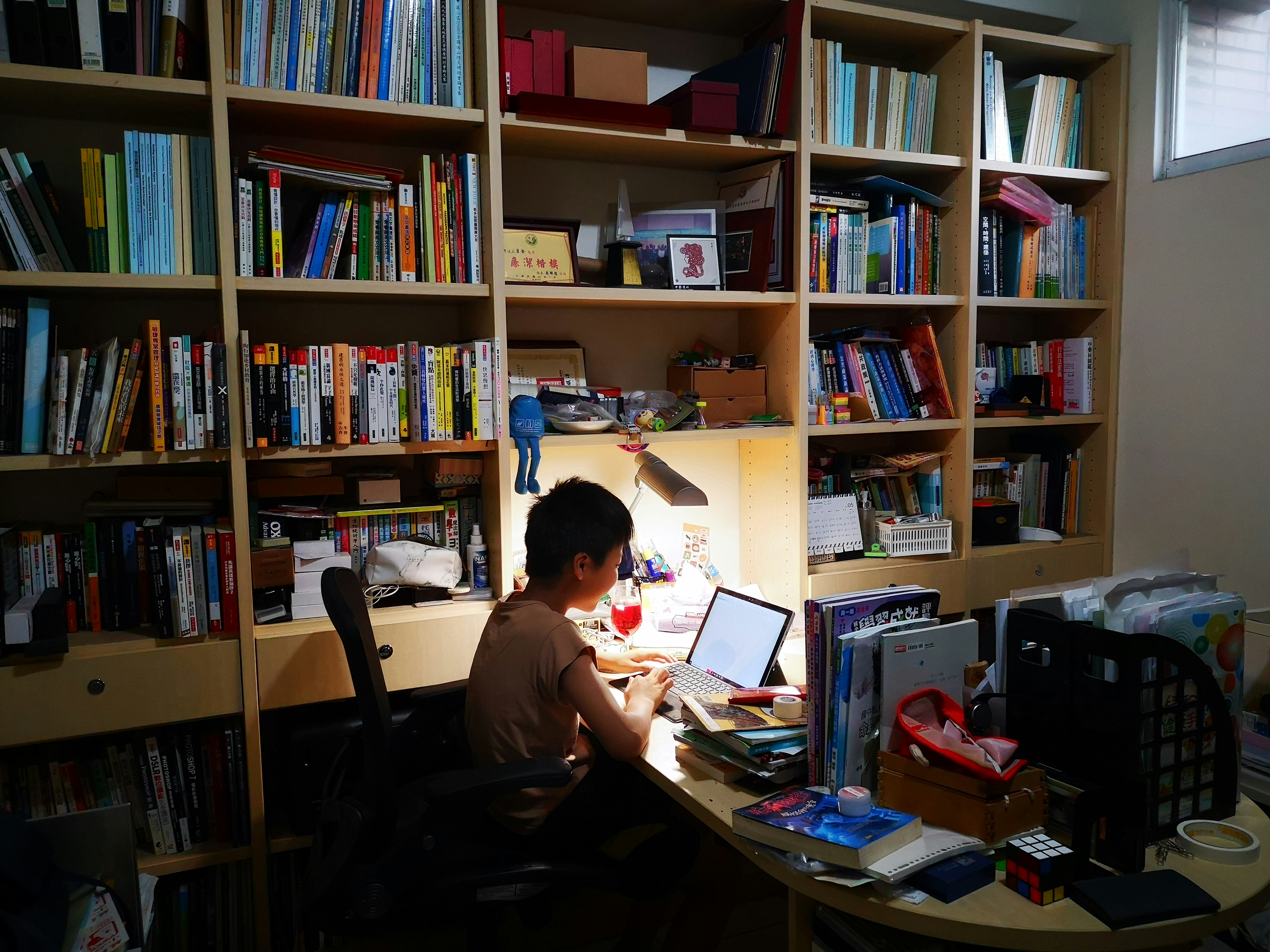 Child coding at desk with books