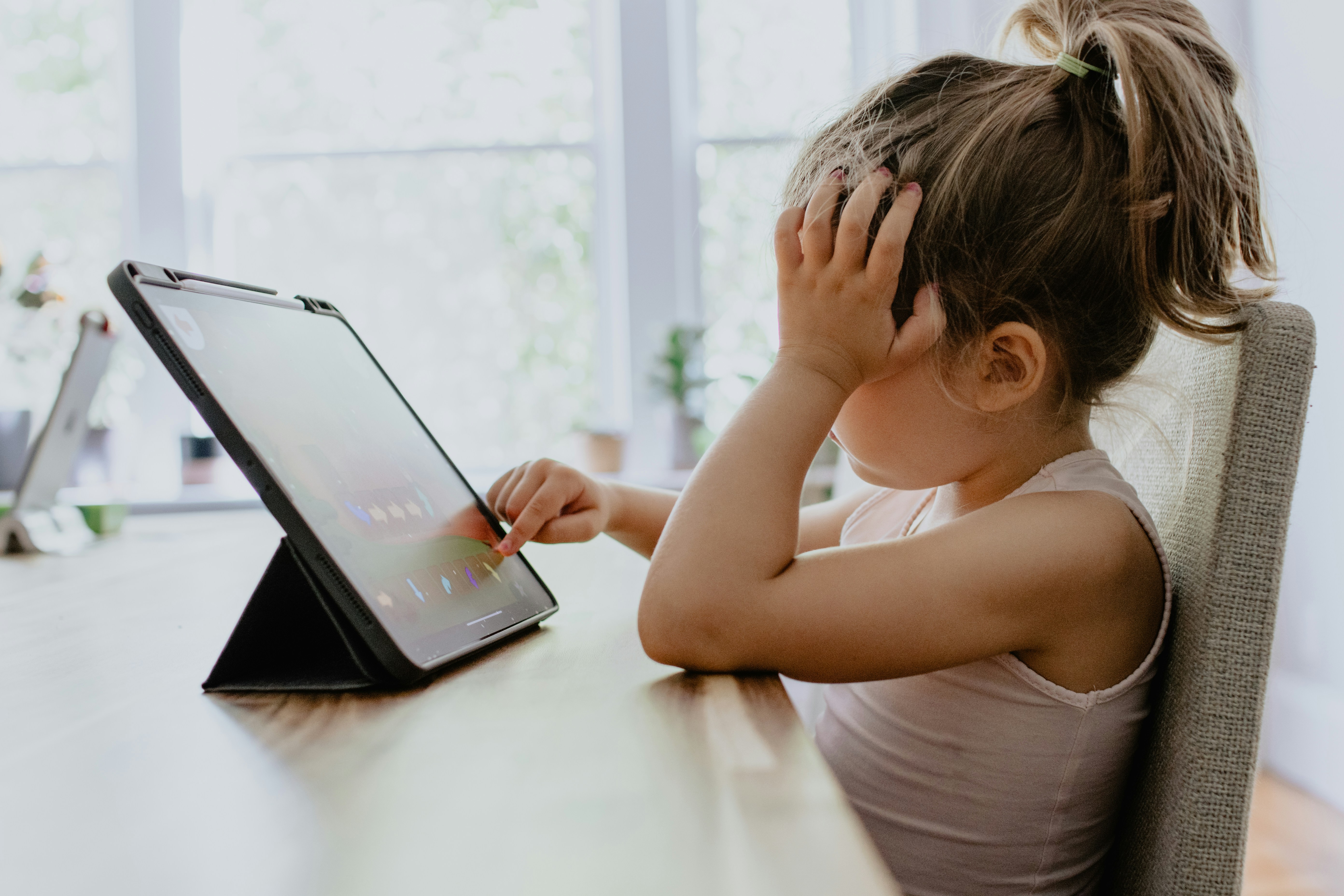 Young girl learning to code on tablet